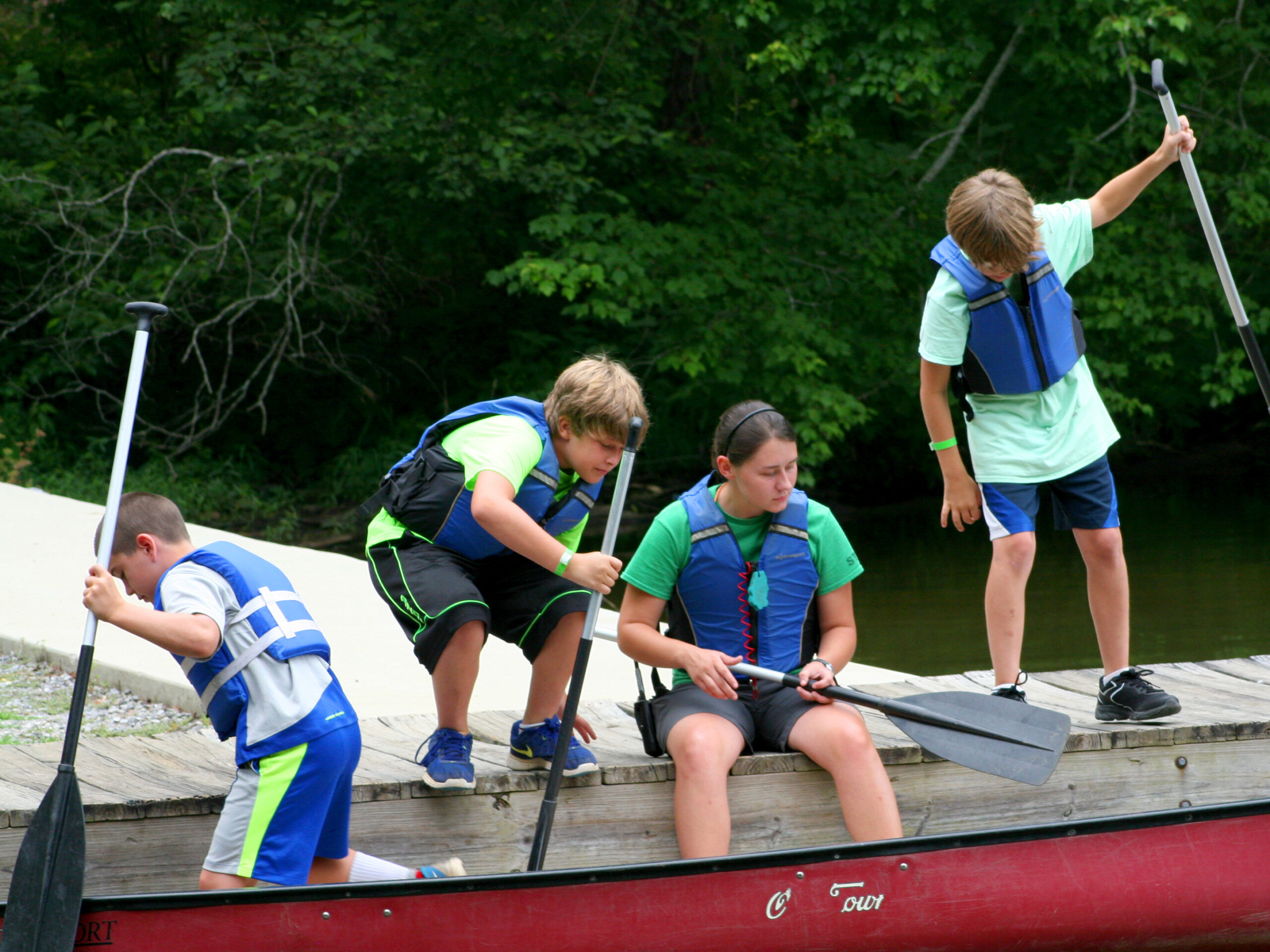 boy on the dock getting into canoes